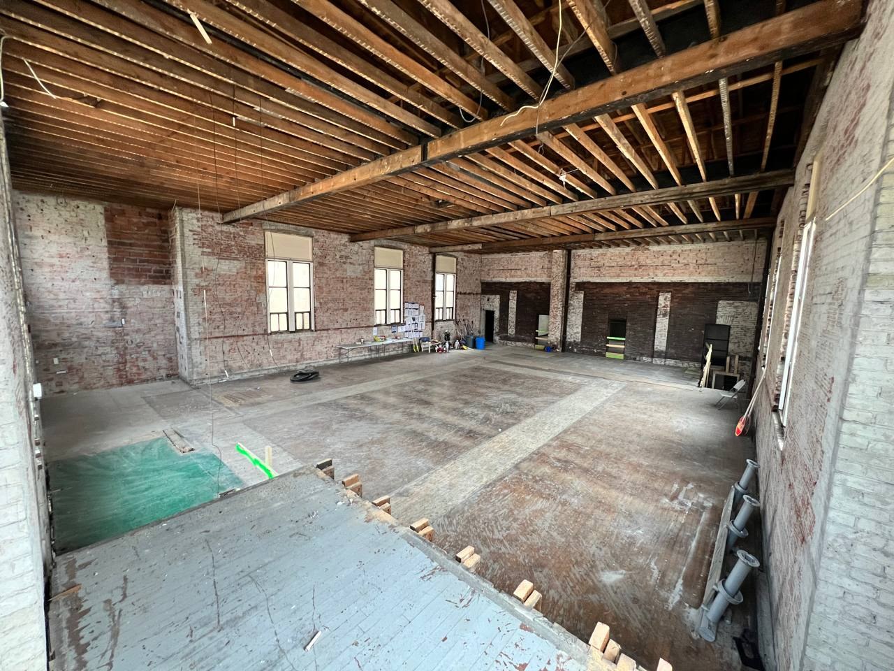 Brick building interior stripped back to the joists and floorboards after selective interior demolition